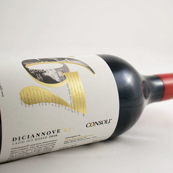 Bottiglia di vino rosso con chiusura del tappo in ceralacca con etichetta in carta bianca decorata in lamina oro e rilievo serigrafico.